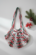 Christmas variegated crochet market bag with pine sprigs and gift box flat lay